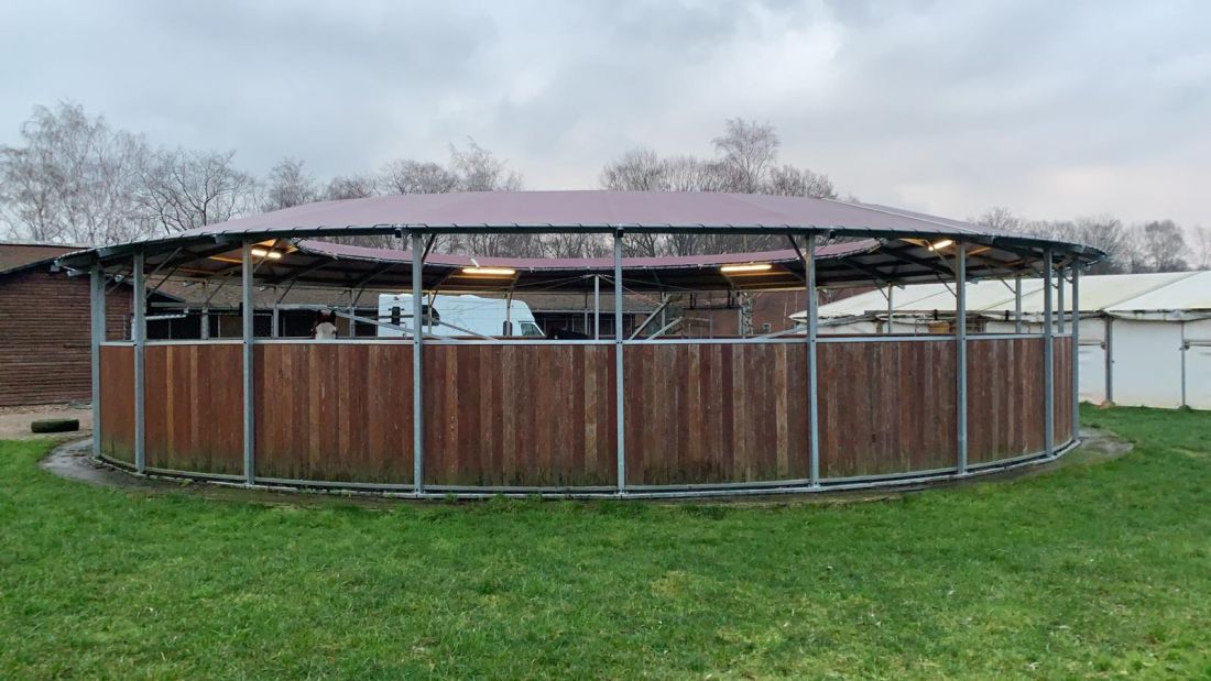 Überdachte Führanlage mit halb hoher Holzverkleidung